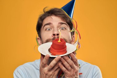 Sarı bir arka plan tatilinde elinde pasta olan bir adam manzarayı kesmiş.