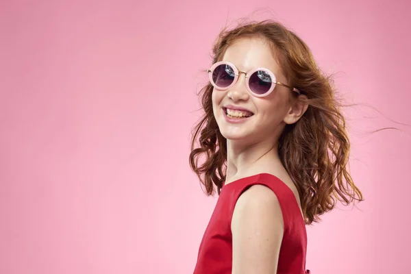 Girl with curly hair sunglasses childhood joy pink background — Stock Photo, Image