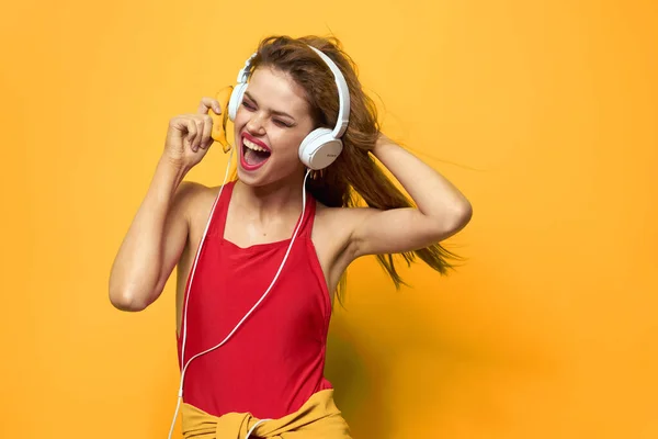 Emotional woman in white headphones listens to music fun lifestyle yellow background — Stock Photo, Image