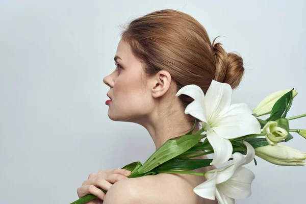 Hermosa chica con un ramo de flores blancas sobre un fondo claro hombros desnudos piel limpia primavera — Foto de Stock
