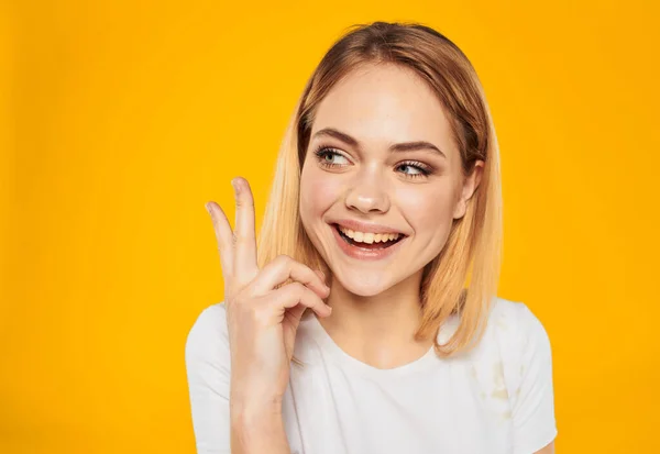 Mulher mostra gesto positivo dois dedos perto modelo rosto emoções — Fotografia de Stock