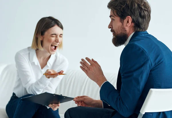Ein Mann im Anzug sitzt auf einem Stuhl und eine Frau auf einem Sofa Psychologe kommuniziert — Stockfoto