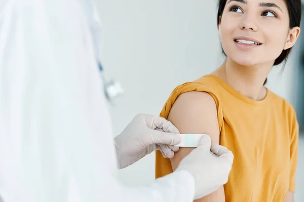 Médico cuidadoso en guantes protectores para pegar la inyección a una mujer covid —  Fotos de Stock