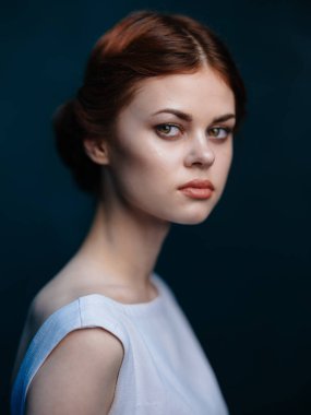 Çekici bir kadın. Kızıl saçlı, beyaz elbiseli, saç modeli.