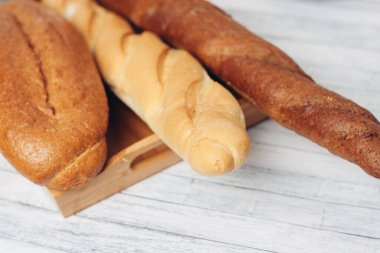 Tahta bir masanın üzerinde ekmek, mutfak bıçağı, kahvaltı.