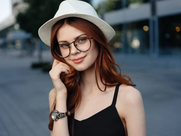 Donna attraente che cammina per strada indossando cappello e occhiali — Foto Stock