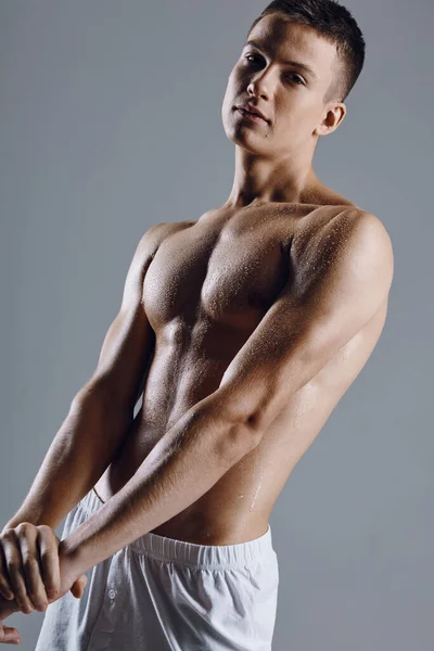 Atleta masculino atraente com músculos do braço bombeados no fundo cinza vista cortada — Fotografia de Stock