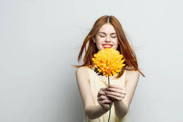 Vidám szép nő egy nagy sárga virág a kezében érzelmek piros ajkak szórakoztató varázsa — Stock Fotó
