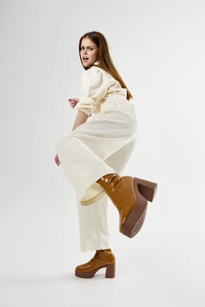 Емоційна жінка в білому комбінезоні коричневе взуття ізольований фон — стокове фото