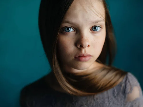 Gadis kecil lucu model dengan latar belakang hijau dengan gaun abu-abu dan gaya rambut — Stok Foto