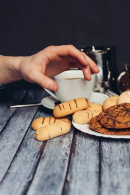Kurabiyeler tabakta bir fincan çay ahşap masada bir aperatif