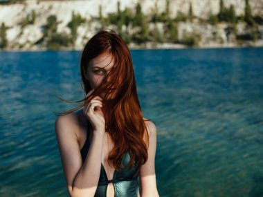 Yeşil mayo giyen çekici bir kadın. Kızıl saçlı. Açık deniz nehri.