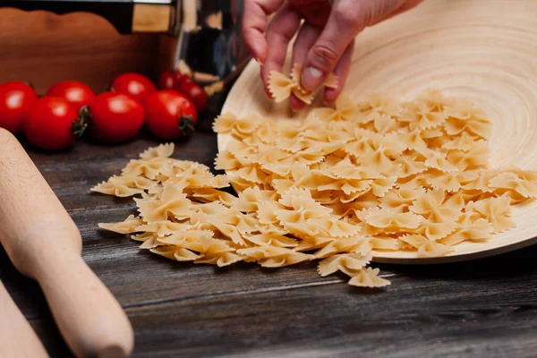 Pasta italiana su un tavolo di legno pomodorini ciliegini pranzo di cottura — Foto Stock