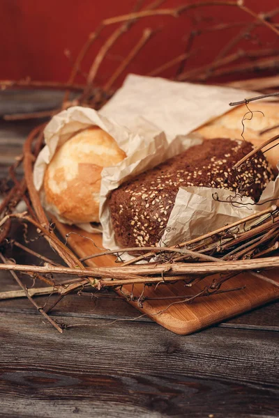 Pieczenie bochenka mąki chlebowej w gnieździe na drewnianym stole — Zdjęcie stockowe