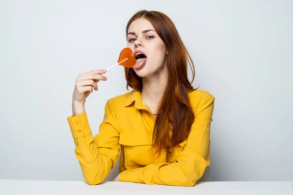 Mujer en camisa amarilla piruleta corazón encanto estilo de vida — Foto de Stock