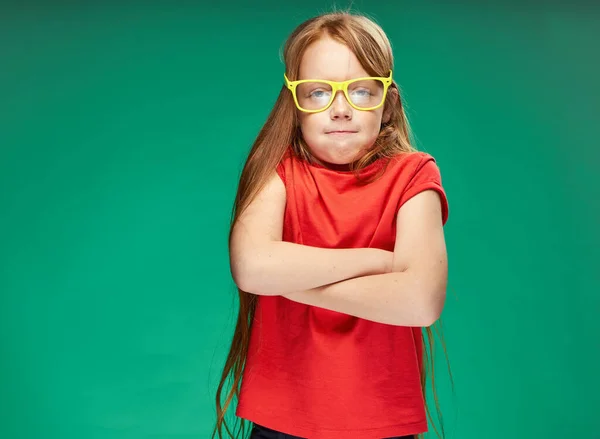 可愛い赤髪の女の子の感情黄色の眼鏡トレーニング緑の背景 — ストック写真