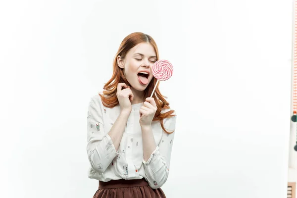 사탕을 손에 쥐고 달콤 한 디저트 를 먹는 유쾌 한 감정적 여자 — 스톡 사진