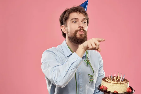 Человек с тортом в тарелке и в голубой рубашке на розовом фоне праздничные дни рождения обрезанный вид — стоковое фото
