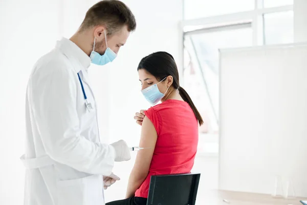 The doctor injects the vaccine into the shoulder of a woman patient health — Stockfoto