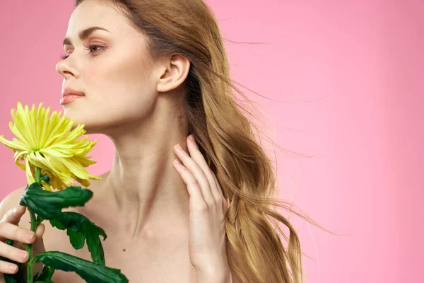 Portret kobiety z żółtymi kwiatami na różowym tle Makijaż na twarzy — Zdjęcie stockowe