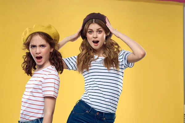 Divertido mamá e hija usando sombreros moda diversión alegría familia amarillo fondo —  Fotos de Stock