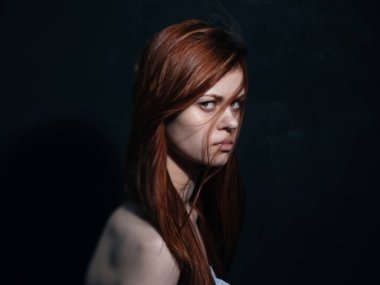 Siyah arka planda kızıl saçlı romantik bir kadın. Yakın plan portresi.