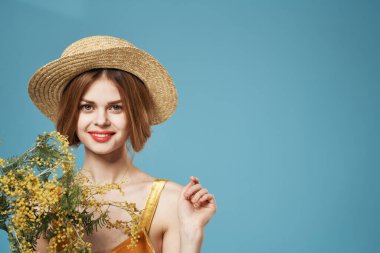 Bir buket çiçekli şapkalı kadın bayram kadınlarının cazibesi mavi arka planda