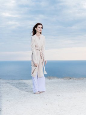 Kadın, arka planda okyanusta, doğa yollarında seyahat eder.