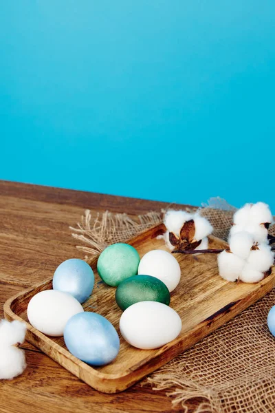 Huevos coloridos tablero de madera decoración fondo azul —  Fotos de Stock