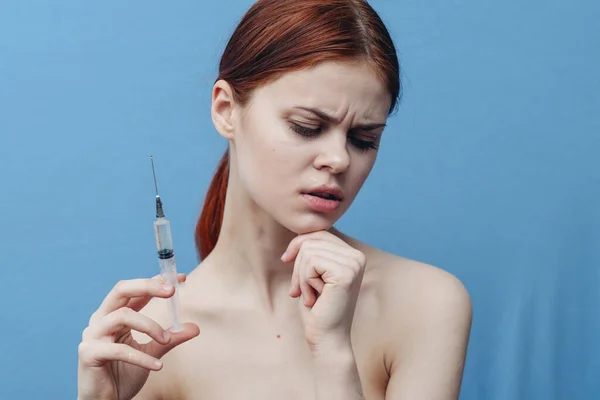 Jeringa en mano de mujer sobre fondo azul inyección rejuvenecimiento botox vista recortada — Foto de Stock