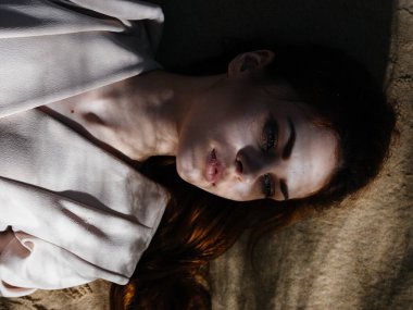 Kadın kumlara uzanıp yaz güneşini dinlendiriyor.