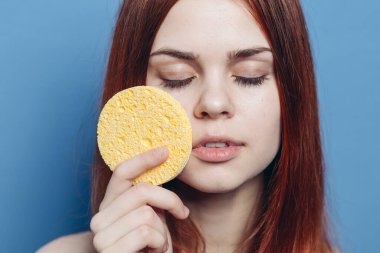 Çekici bir kadın, kızıl, çıplak omuzlar, el bakımı süngerler.