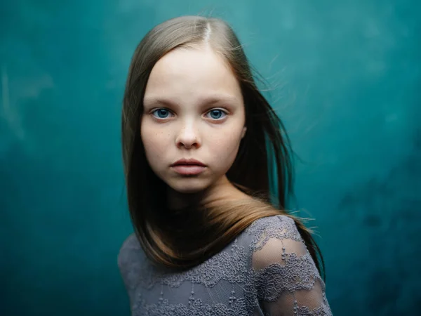 Портрет красивой девушки в сером платье и светлые волосы на бирюзовом фоне — стоковое фото