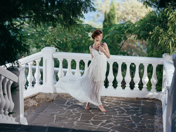 Krásná žena v bílých šatech tradiční řecké oblečení příroda zelené listy — Stock fotografie