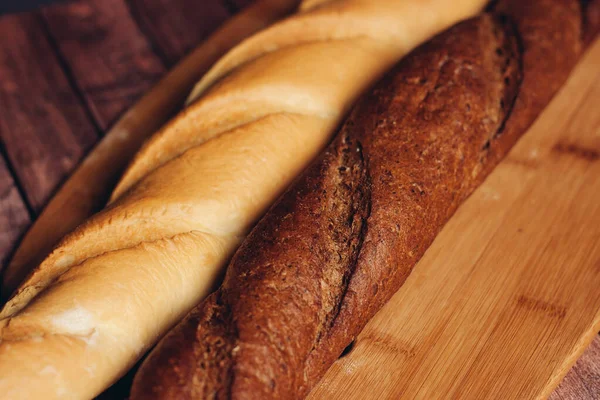 Szeletelt kenyér fából készült vágódeszkás konyhai ételen — Stock Fotó