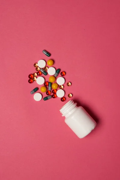Ανοιχτό βάζο με χάπια σε ροζ φόντο coldspace top view — Φωτογραφία Αρχείου