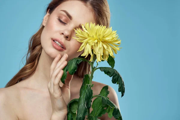 Krásná žena se žlutou květinou v blízkosti obličeje usmívající se oříznutý pohled portrét obnažených ramen — Stock fotografie