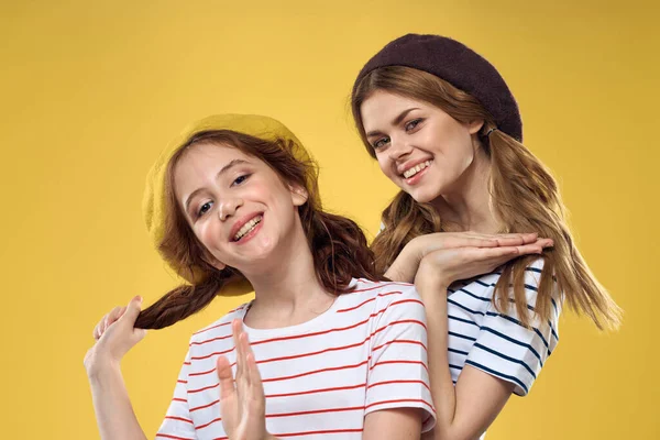 Lustige Mutter und Tochter tragen Hüte Mode Spaß Familie gelb Hintergrund — Stockfoto