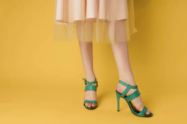 Sapatos de moda sapatos verdes pés femininos compras fundo amarelo — Fotografia de Stock