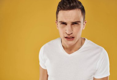 Öfkeli bir adam sarı arka planda duygu ve stresten ağlıyor.