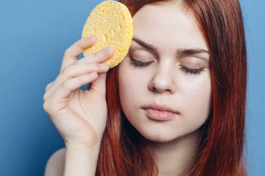 Güzel, kızıl saçlı, çıplak omuzlu, yüzü süngerle silinmiş.