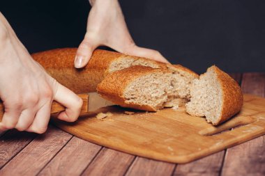 Kesme tahtası mutfağında taze bir somun dilimliyorum.