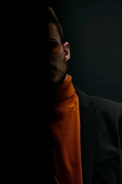 Silhouette of a man in a sweater and jacket on a black background falling shadow — Stock Photo, Image