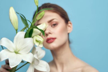 Mavi arka planda beyaz çiçekli çekici bir kadın. Kesilmiş bir manzara.