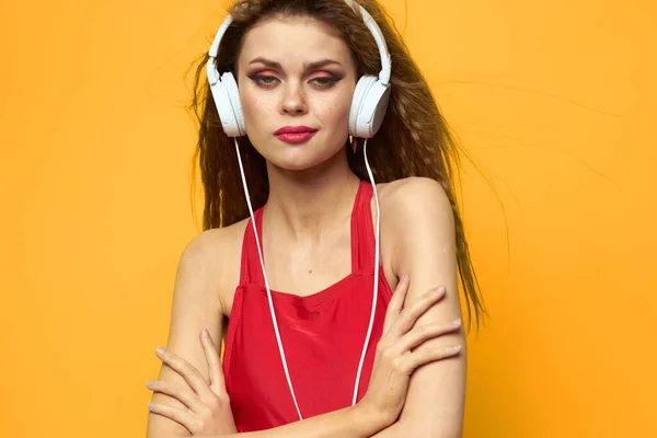 Mujer en auriculares escuchando música rojo camiseta emociones moda amarillo fondo estilo de vida —  Fotos de Stock