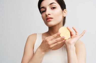 Elinde sünger tutan güzel bir esmer. Temiz, sıcacık bir cilt.