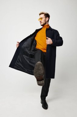 Duygusal adam koyu renk ceketli turuncu gözlüklü.