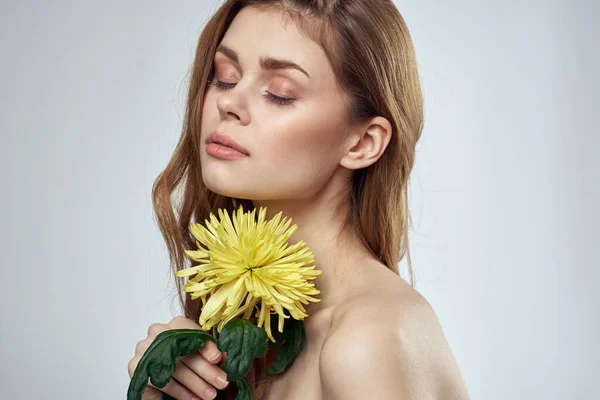 Portré egy gyönyörű nő egy sárga virág egy könnyű háttér bájos mosoly modell piros haj — Stock Fotó