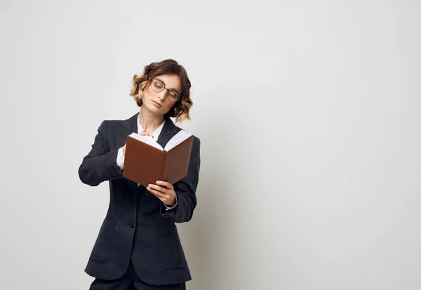 Una donna in un abito classico con un libro in mano occhiali sul suo volto modello di armadio da lavoro — Foto Stock