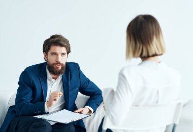 Bir erkek, belgeleri olan bir psikolog ve doktor randevusundaki bir kadın.